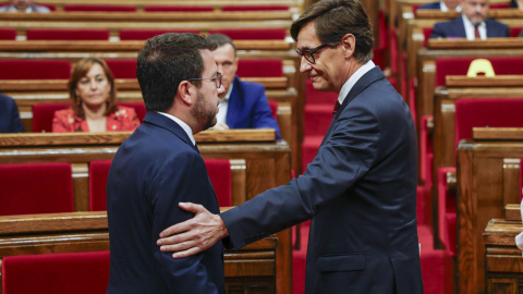 El presidente de la Generalitat en funciones, Pere Aragonès (i), conversa con el candidato a la investidura, Salvador Illa, este jueves en la Cámara autonómica.