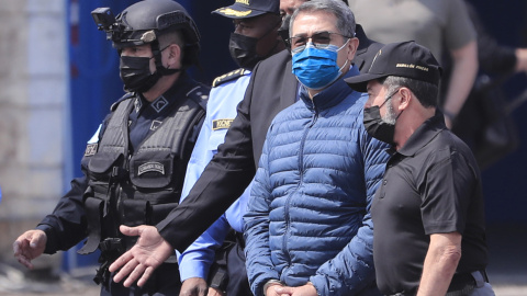 22/04/2022 - El expresidente hondureño Juan Orlando Hernández es dirigido a la aeronave que lo llevará extraditado a los Estados Unidos hoy, en la base aérea Hernán Acosta de Tegucigalpa (Honduras).