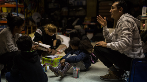 Julio Aponte junto a su mujer Margareth Jiménez (izquierda), juegan con sus hijos en la habitación de la parroquia San Carlos Borromeo de Entrevías, donde llevan casi cinco meses esperando una plaza en el sistema de asilo y refugio.- JAIRO VARGAS