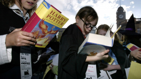 Un grupo de niños leyendo la contraportada del último libro de la saga Harry Potter.