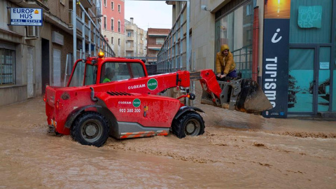 Un tractor traslada a un vecino del municipio de Los Alcázares, para cruzar una calle inundada hoy por las intensas lluvias caídas esta noche, de más de cien litros por metro cuadrado. EFE/Marcial Guillén