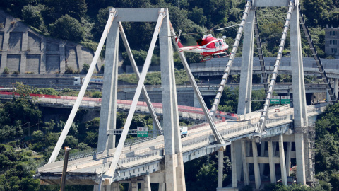 Un helicóptero de los bomberos sobrevuela la zona del puente Morandi, que se desplomó el pasado martes. REUTERS/Stefano Rellandini