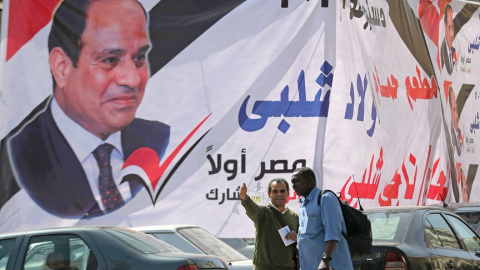 09/04/2019 - Dos hombres frente a un cartel del presidente egipcio Abdel Fattah al-Sisi días antes del referéndum para reformar la Constitución. / REUTERS - MOHAMED ABD EL GHANY