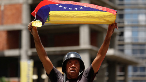 Un manifestante sostiene una bandera de Venezuela durante una marcha en protesta por los resultados de las elecciones, en Caracas. — Leonardo Fernandez Viloria / REUTERS