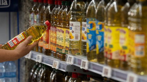 Una persona coge una botella de aceite, en una imagen de archivo.