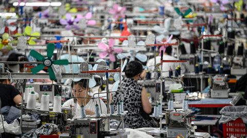 Trabajadores producen prendas en una fábrica textil que suministra ropa a un comercio electrónico de 'fast fashion', en Guangzhou (China), a 11 de junio de 2024.