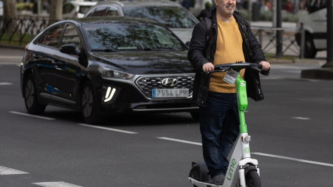 Un hombre montado en un patinete eléctrico en Madrid.