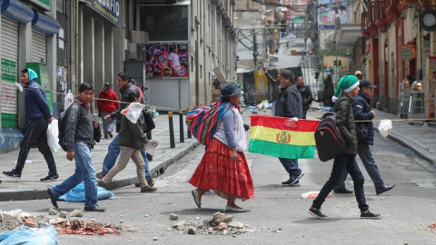 Gente paseando por las calles con una bandera de Bolivia. / EFE