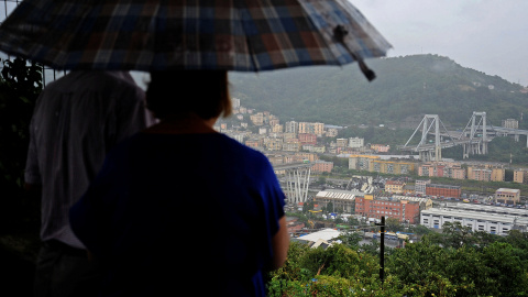 Una pareja observa el puente de Morandi tras el accidente. / REUTERS