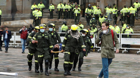 BOGOTÁ (COLOMBIA), 22/11/2019.- Miembros de los equipos de emergencia atienden a un herido durante un cacerolazo este viernes, en la Plaza Bolívar de Bogotá (Colombia). El rezago de las protestas de ayer en Colombia contra las políticas del Gobierno d