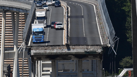 Varios vehículos permanecen sobre una sección de un puente que continúa en pie tras el desplome de un tramo el martes en Génova (Italia). EFE/ Luca Zennaro