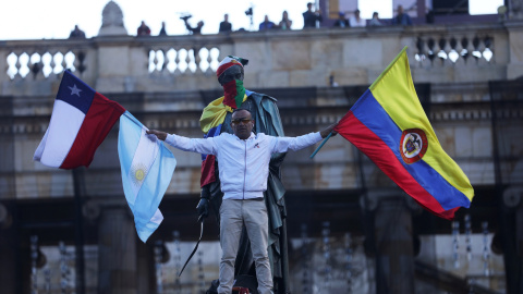 Un manifestante sostiene banderas nacionales colombianas, chilenas y argentinas durante una protesta mientras continúa una huelga nacional en Bogotá, Colombia, 4 de diciembre de 2019. REUTERS / Luisa Gonzalez