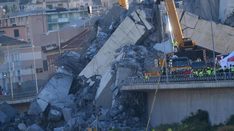 Una grúa trabaja en las labores de búsqueda de víctimas y retirada de los escombros del puente que el martes se desplomó en Génova (Italia). EFE/ Luca Zennaro