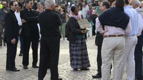 Una mujer suplica a los sacerdotes católicos en la Plaza Mayor de Madrid el 26 de septiembre de 2014.