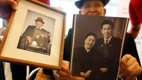 Un surcoreano enseña una de las fotos que dará a su familia en una de las reuniones organizada entre las dos Coreas - EFE