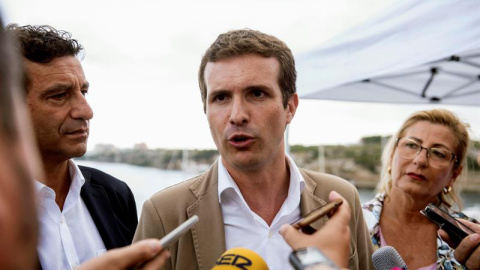 23/08/2018.- El presidente del PP, Pablo Casado (c), junto al presidente del partido en Baleares, Biel Company (i), y la presidenta del PP de Menorca, Misericordia Sugrañes (d), atiende a los medios de comunicación durante la visita que realiza hoy al C