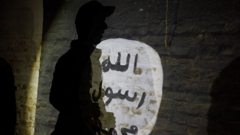 La sombra de un hombre armado vista sobre una pintada con el símbolo del Estado Islámico.REUTERS/Alaa al-Marjani