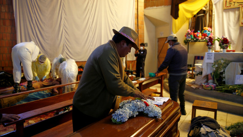 Un hombre deja flores sobre el ataúd de uno de los muertos en durante los enfrentamientos en la planta de gas de Senkata, en la ciudad de El Alto, Bolivia.-  REUTERS/David Mercado