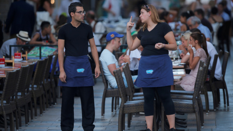 Una camarera conversa con un compañero de trabajo en una terraza de un restaurante en la localidad malagueña de Ronda. REUTERS/Jon Nazca