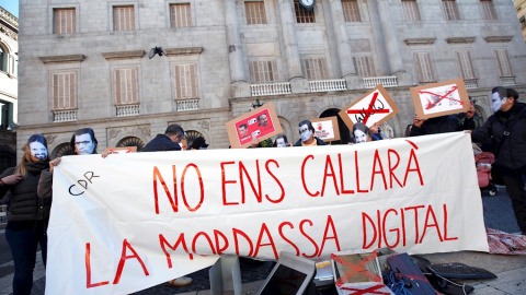 Varias personas sostienen una pancarta en la que se puede leer 'No nos callará la mordaza digital' durante una manifestación convocada por los CDR en protesta contra la Ley mordaza frente al ayuntamiento de Barcelona este sábado. EFE/Alejandro García