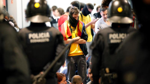 Agentes de los Mossos d'Esquadra controlan a los simpatizantes independentistas que han conseguido entrar en el T1 del Aeropuerto de El Prat tras el anuncio de la plataforma Tsunami Democràtic que ha llamado a paralizar la actividad del aeropuerto, en pr