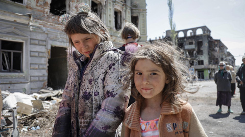 Dos niñas caminan por las ruinas de la ciudad devastada de Mariúpol (Ucrania) durante el Día de la Victoria, este 9 de mayo de 2022.