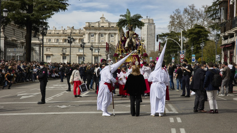 Numerosas personas atienden el paso de la Imagen de Jesús con la Borriquita, por el centro de Madrid, a 10 de abril de 2022, en Madrid (España).