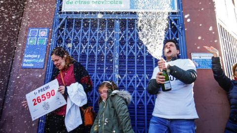 Laura Puentes, propietaria de la administración de lotería situada en la Rambla Guipúzcoa de Barcelona celebra con su marido y su hija las cinco series vendidas del número 26.590, agraciado con el Gordo de Navidad. /EFE