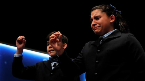 La niña Nerea Pareja que, junto a su compañero del colegio de San ildefonso Alfonso Dávalos (i), ha cantado el primero de los quintos premios del Sorteo Extraordinario de la Lotería de Navidad que ha correspondido al número 75.206, se emociona al mos