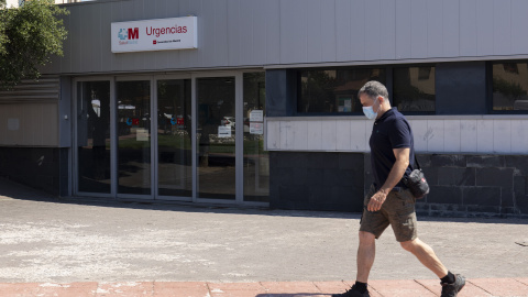 Un hombre pasea frente a la entrada de urgencias del ambulatorio de Moralzarzal.