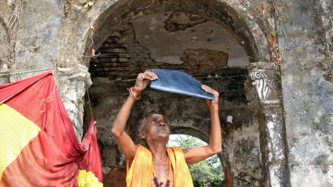 26/12/2019 - Un sacerdote hindú observa el eclipse a través de una película de rayos X fuera de un templo en Agartala, India. REUTERS / Jayanta Dey