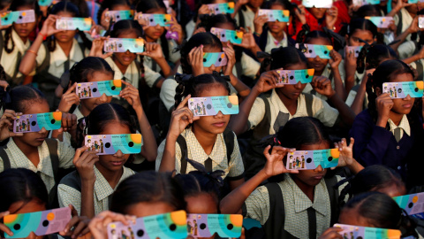 26/12/2019 - Niñas usando gafas solares para ver el eclipse en Ahmedabad, India. REUTERS / Amit Dave