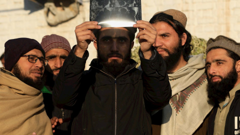 26/12/2019 - Personas usando una placa de rayos X para mirar el eclipse solar en Peshawar, Pakistán. EFE / BILAWAL ARBAB