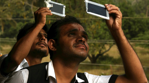 26/12/2019.- Dos personas usando vidrio oscuro para ver el eclipse solar en Mysore, India. EFE / EPA / JAGADEESH NV