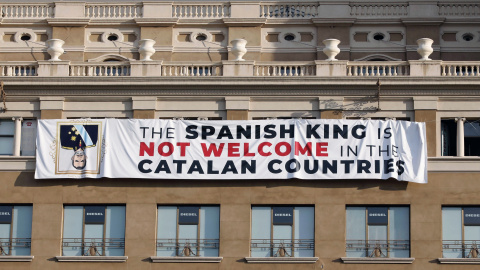 Activistas cuelgan una pancarta contra el rey en la plaza de Catalunya./EFE