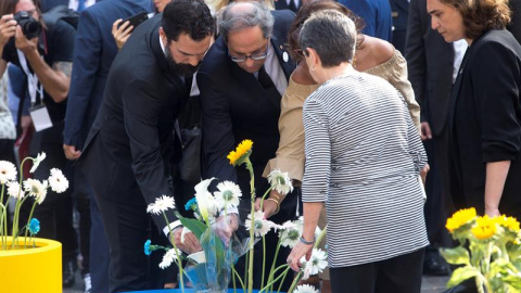 Algunas autoridades también han querido rendir homenaje simbólicamente dejando flores en los maceteros que se han habilitado para ello en Barcelona. | EFE / Quique García