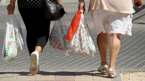 Dos mujeres llevan varias bolsas de plástico/EFE