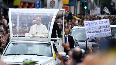 Francisco, en el Papamóvil, pasa junto a una pancarta de protesta contra los abusos a menores de la Iglesia. - REUTERS