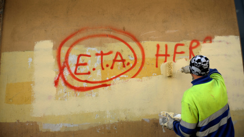 Un empleado municipal tapa una pintada que pone 'ETA, el pueblo está contigo', en Gernica, en octubre de 2011, al día siguiente del anunio de la organización terrorista del cese de su actividad armada. REUTERS/Vincent West