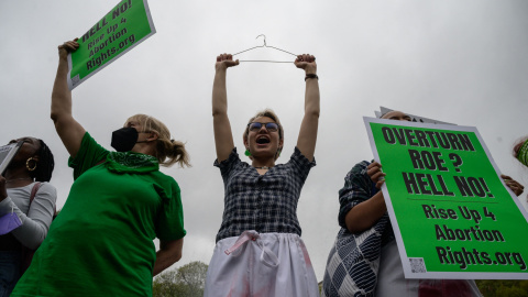 Un manifestante sostiene una percha, un símbolo del movimiento por los derechos reproductivos, mientras los activistas organizan una protesta de "muerte" en el parque Washington Square en Nueva York el 13 de mayo de 2022.