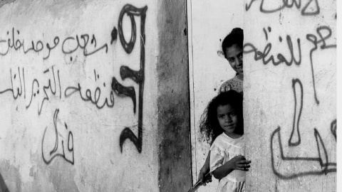 Foto del 1 de septiembre de dos niñas palestinas, en la localidad de Jericó. Los muros de sus casas tienen pintadas de la OLP a favor del acuerdo de paz con Israel. AFP/Yoav Lemmer