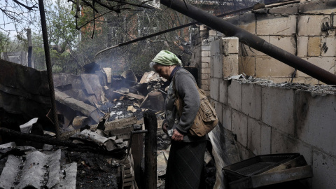 14/05/2022 Vera Kosolopenko camina entre los escombros de su vivienda, destruida por los bombardeos rusos en Derhachi, cerca de Járkov (Ucrania)