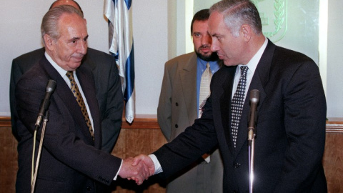 Benjamin Netanyahu y Shimon Peres se estrechan la mano en la ceremonia de traspaso de poderes al frente del Gobierno de Israel, en junio de 1996. AFP/Menahem Kahana