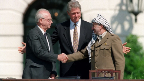 El primer ministro israelí, Isaac Rabin, y el líder de la OLP, Yasser Arafat, se estrechan la mano en presencia del presidente de EEUU, Bill Clinton, en los jardines de la Casa Blanca, en Washington, para sellar los Acuerdos de Oslo, el 13 de septiembre