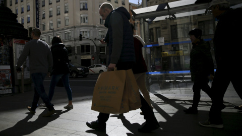 Varias personas con las bolsas de sus compras por el centro de Madrid. REUTERS/Andrea Comas