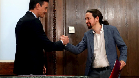 30/12/2019.- El candidato a la investidura, Pedro Sánchez (i), y el líder de Podemos, Pablo Iglesias (d), estrechan su s manos durante el acto de firma del acuerdo programático. / EFE - JUANJO MARTÍN