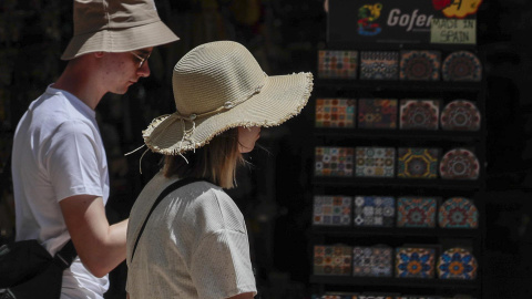 19/05/2022-Dos turistas pasean con sombreros para protegerse del calor que impera en València este jueves 19 de mayo