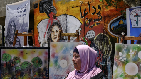 19/05/2022-Una mujer se encuentra este viernes 19 de mayo delante de un mural, que forma parte de una exposición de arte en honor a la periodista Shireen Abu Akleh, en el lugar donde fue asesinada