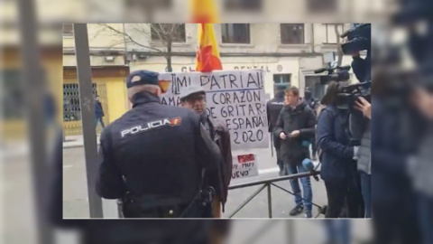 Un policía disuade al hombre que protestaba frente a Ferraz en defensa de la unidad de España./ Europa Press