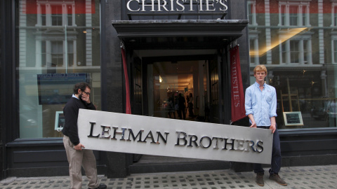 Dos empleados sujetan el letrero de la empresa Lehman Brothers. REUTERS/Andrew Winning